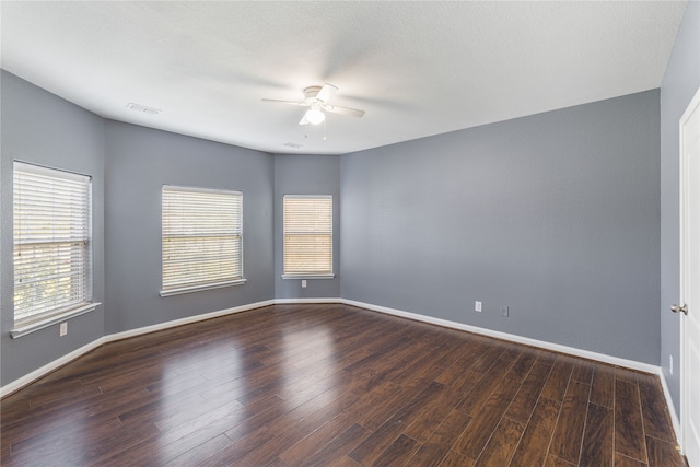 empty room featuring a textured ceiling, dark hardwood / wood-style floors, and ceiling fan