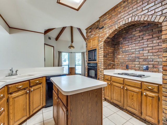 kitchen with brick wall, sink, black appliances, light tile patterned flooring, and a kitchen island