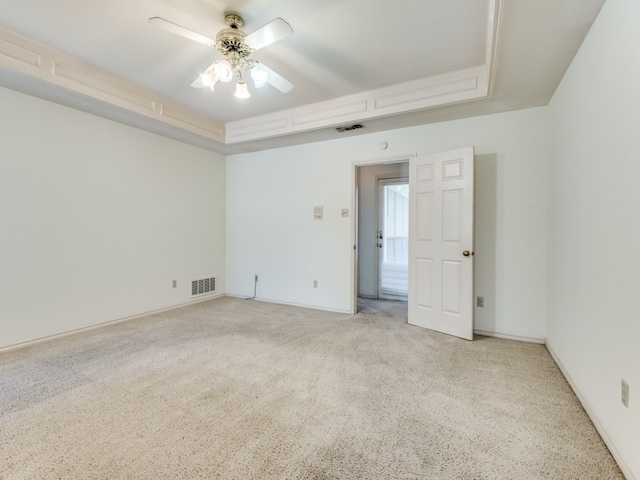 unfurnished room with carpet flooring, ceiling fan, and a tray ceiling