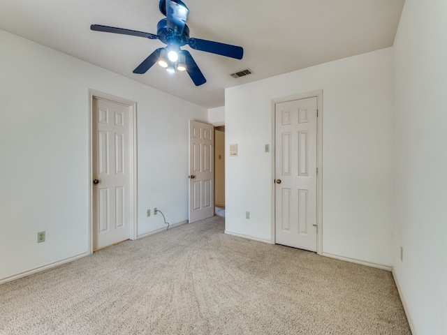 unfurnished bedroom featuring light colored carpet and ceiling fan