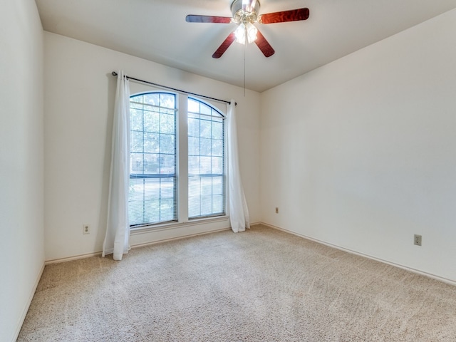 unfurnished room with ceiling fan and light carpet