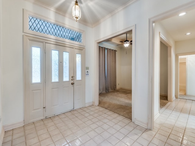 entrance foyer with crown molding and light colored carpet