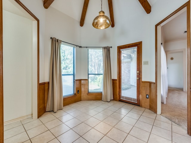 unfurnished room with wood walls, high vaulted ceiling, light tile patterned floors, and beam ceiling