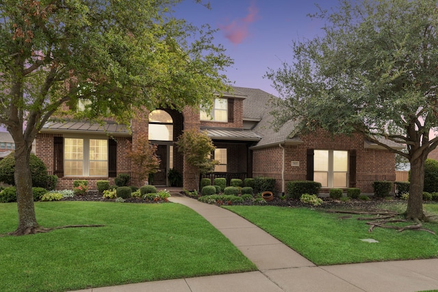 3113 Wimberley Ln, Rockwall, TX 75032 - view of front facade featuring a standing seam roof, brick siding, a front yard, and metal roof