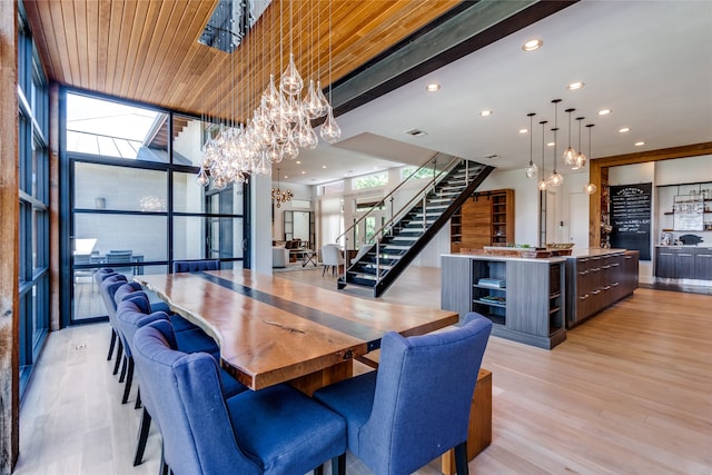 dining room featuring wooden ceiling, floor to ceiling windows, an inviting chandelier, and light hardwood / wood-style floors