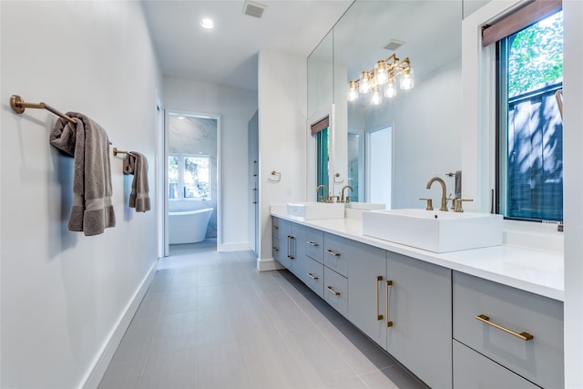 bathroom featuring vanity, tile patterned flooring, and a bathtub