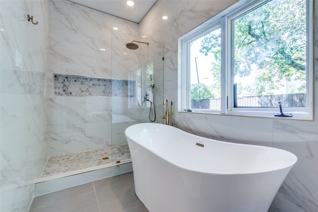 bathroom with tile walls, independent shower and bath, and tile patterned flooring