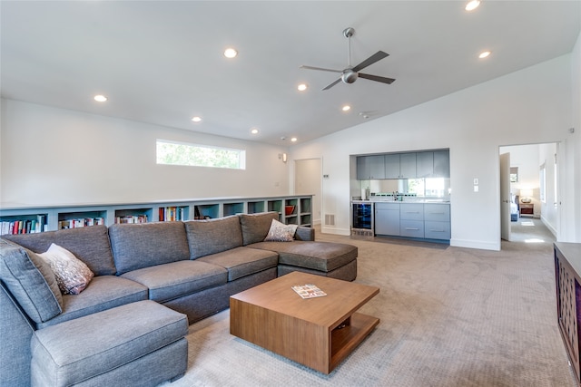 carpeted living room with bar area, vaulted ceiling, wine cooler, and ceiling fan