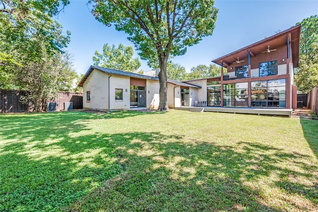 rear view of house featuring a lawn and a wooden deck