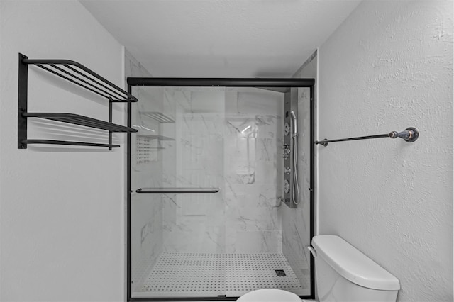 bathroom featuring a textured ceiling, toilet, and a shower with door