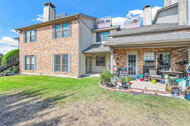 rear view of house featuring a yard and a patio area