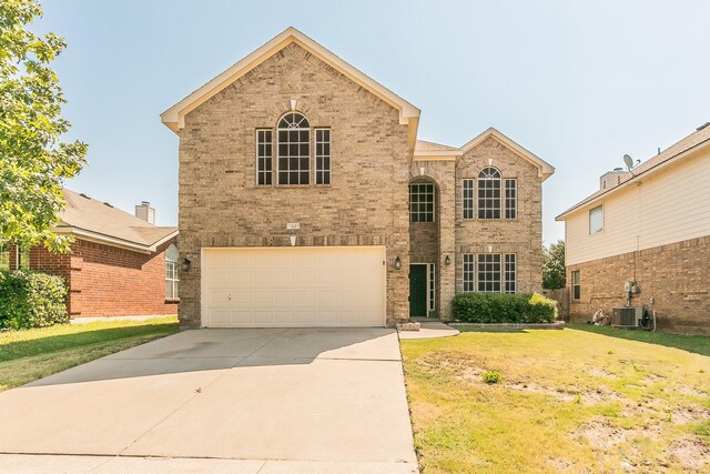 view of front of house with a garage, central AC unit, and a front yard