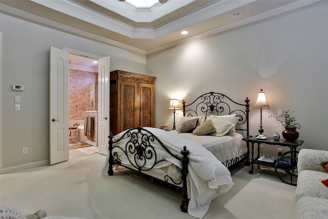 carpeted bedroom with a tray ceiling, ensuite bathroom, and crown molding