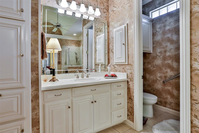 bathroom with toilet, tile patterned floors, vanity, ceiling fan, and a shower with shower door