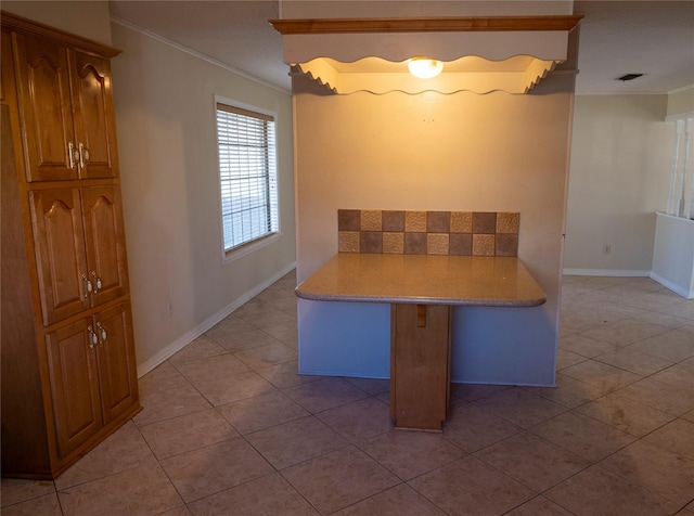 interior space with light tile patterned floors and ornamental molding