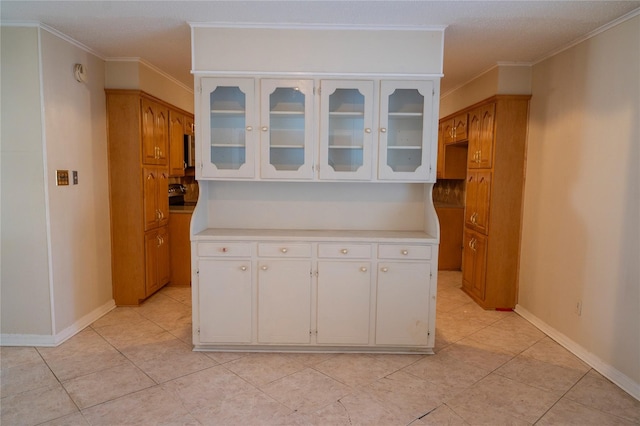 kitchen with ornamental molding, white cabinets, and light tile patterned flooring