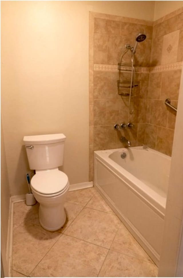 bathroom with toilet, tiled shower / bath combo, and tile patterned floors