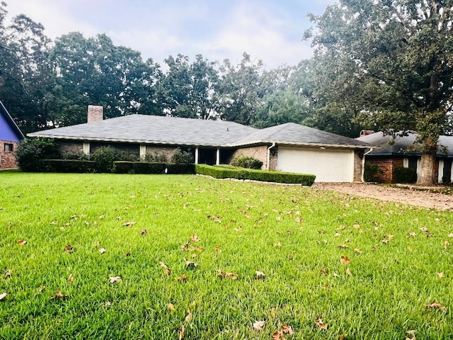 single story home featuring a garage and a front lawn