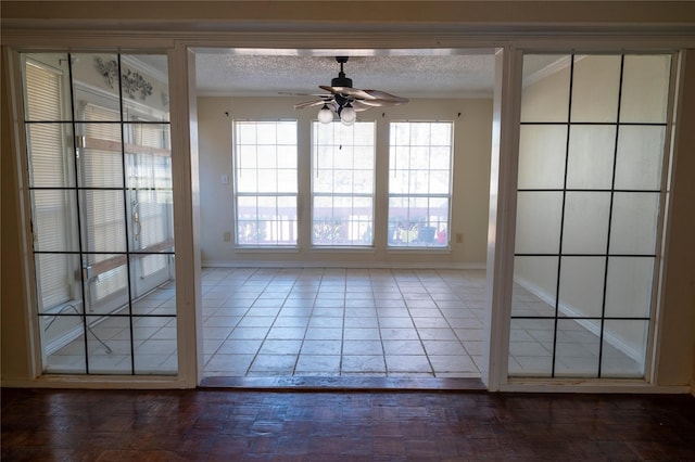 spare room featuring a textured ceiling, dark wood-type flooring, ceiling fan, and crown molding