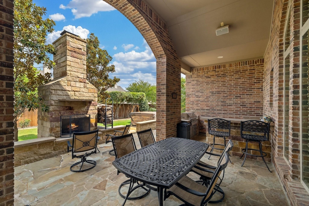 view of patio / terrace featuring a grill and an outdoor stone fireplace