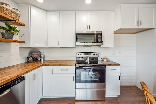 kitchen featuring butcher block countertops, white cabinetry, stainless steel appliances, and dark hardwood / wood-style floors