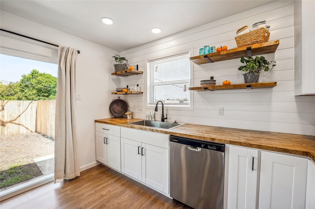 kitchen with white cabinetry, stainless steel dishwasher, butcher block counters, and sink