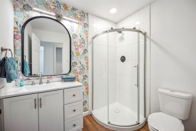 bathroom with an enclosed shower, vanity, and toilet