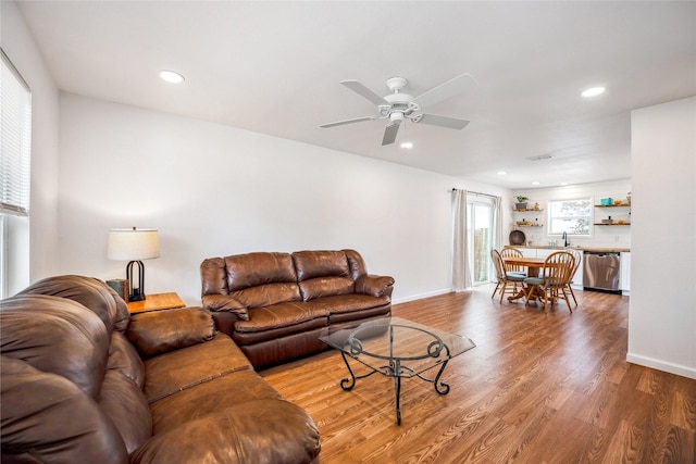 living room featuring hardwood / wood-style floors, ceiling fan, and sink