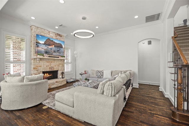 living room featuring dark wood-type flooring, crown molding, and a fireplace