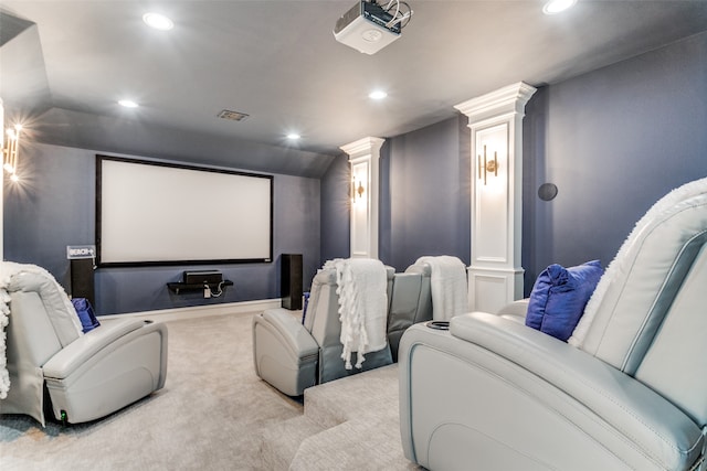 carpeted cinema room featuring decorative columns and vaulted ceiling