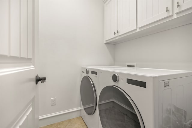 clothes washing area featuring independent washer and dryer, cabinets, and light tile patterned floors