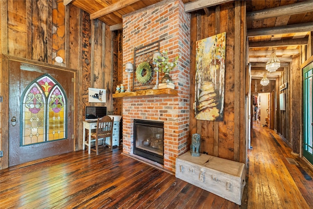 unfurnished living room featuring a fireplace, dark hardwood / wood-style flooring, beamed ceiling, and wooden ceiling