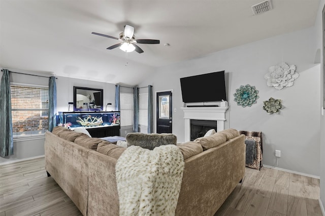 living room with lofted ceiling, light hardwood / wood-style flooring, and ceiling fan