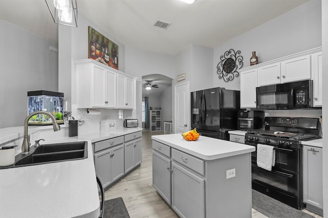 kitchen with black appliances, tasteful backsplash, a center island, sink, and ceiling fan