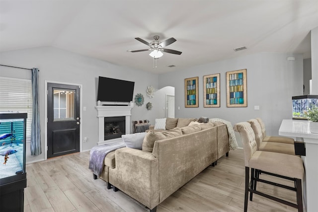 living room featuring ceiling fan, light wood-type flooring, and vaulted ceiling