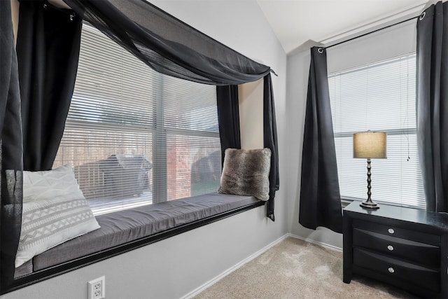 living area featuring vaulted ceiling, plenty of natural light, and light colored carpet