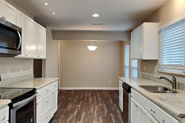 kitchen with pendant lighting, dark hardwood / wood-style flooring, sink, appliances with stainless steel finishes, and white cabinets