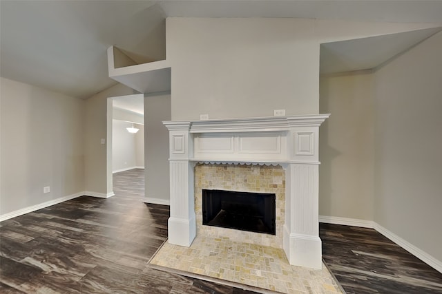 unfurnished living room featuring lofted ceiling, dark hardwood / wood-style floors, and a fireplace