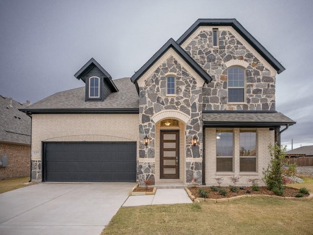 view of front of house featuring a garage and a front lawn