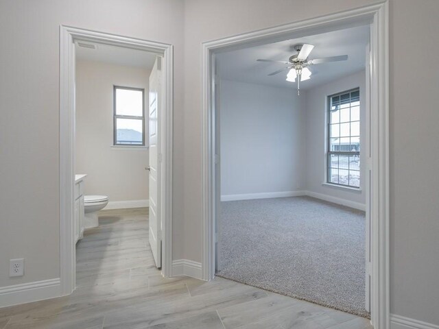 bathroom with wood-type flooring, vanity, toilet, and ceiling fan