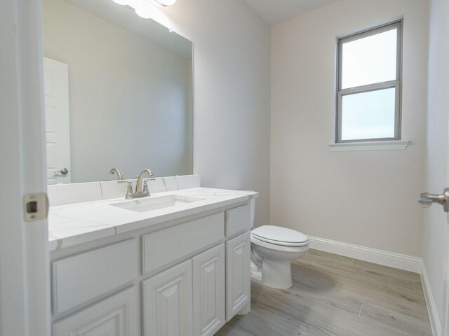 bathroom featuring hardwood / wood-style flooring, vanity, and toilet