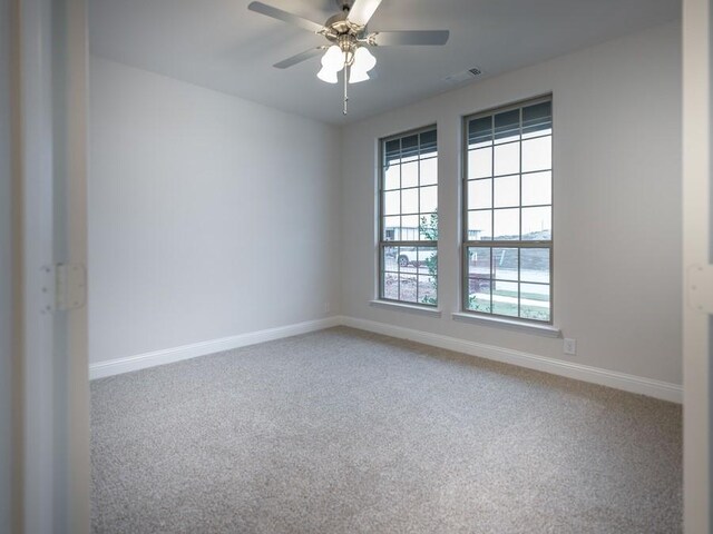 carpeted spare room with ceiling fan and a water view