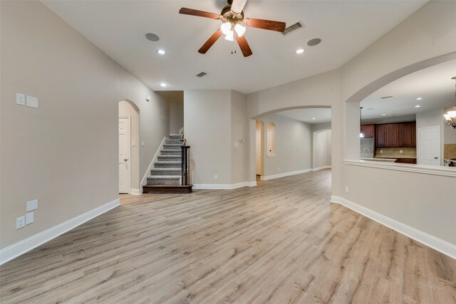 unfurnished living room featuring ceiling fan and light hardwood / wood-style floors