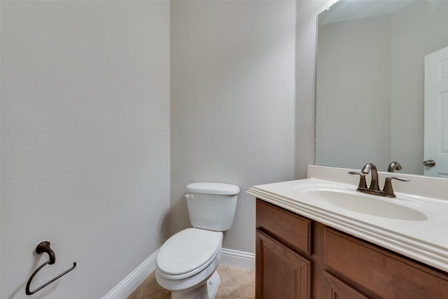 bathroom with tile patterned flooring, vanity, and toilet