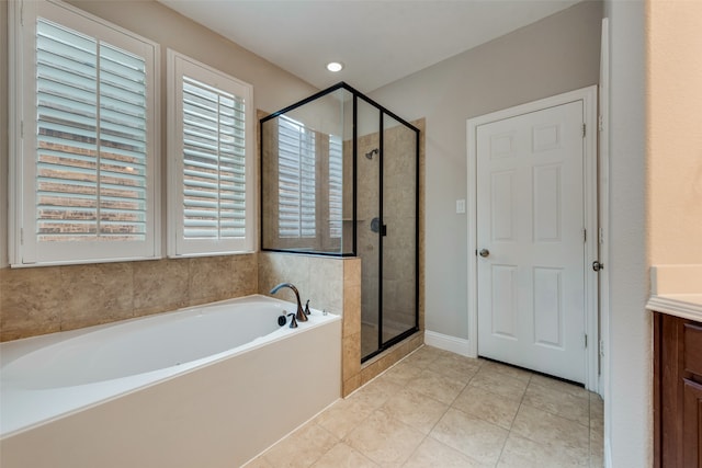 bathroom featuring tile patterned flooring, vanity, and plus walk in shower