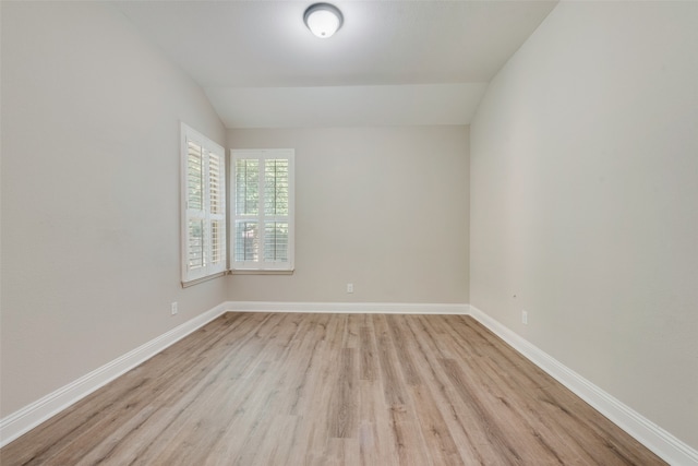 empty room featuring lofted ceiling and light wood-type flooring