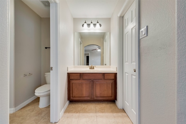 bathroom with vanity, toilet, tile patterned floors, and ceiling fan