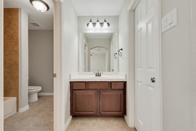 bathroom featuring tile patterned flooring, vanity, toilet, and a bath