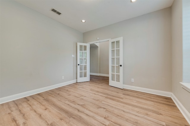 spare room with light wood-type flooring and french doors