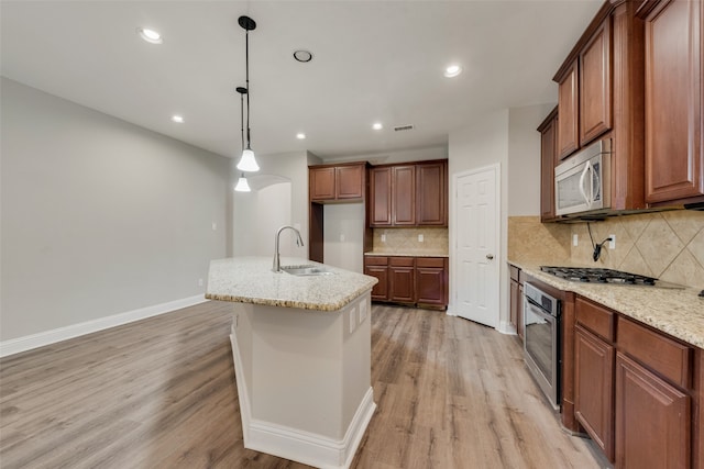 kitchen featuring light stone countertops, stainless steel appliances, light hardwood / wood-style floors, and sink